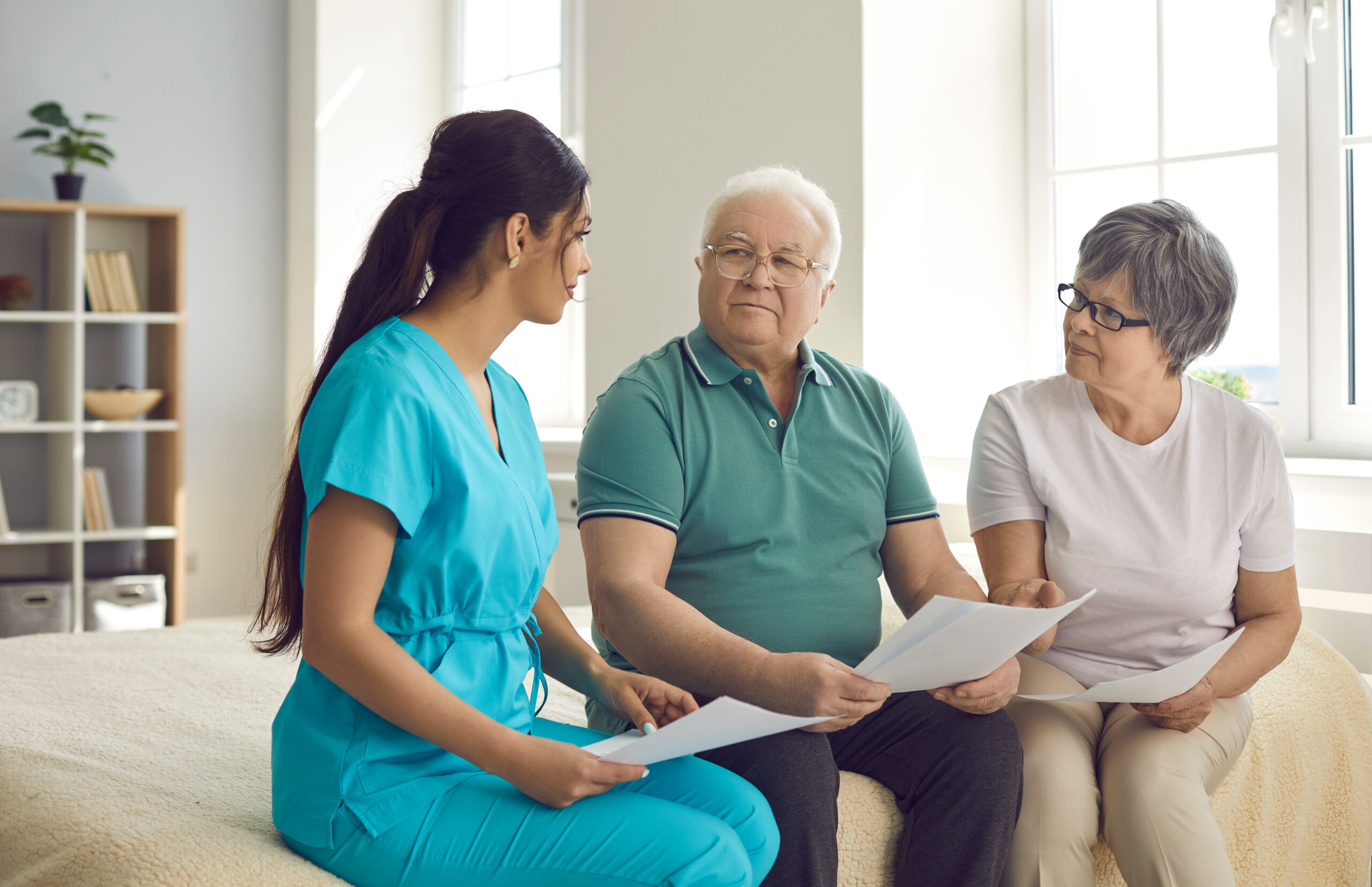 Professional caregiver helps senior patients understand and fill out home care contract
