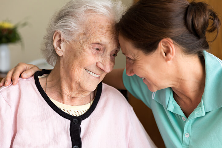 Elderly and caregiver smiling