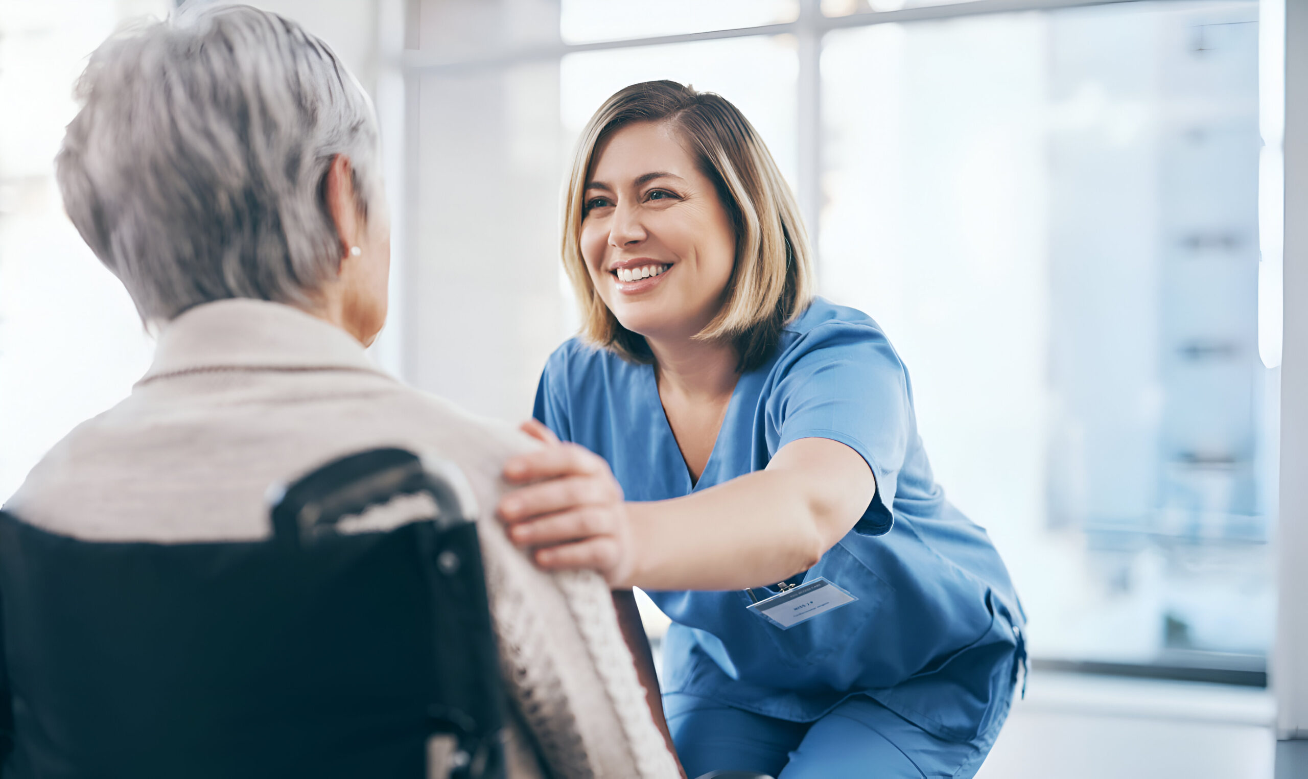 nurse caregiver taking care senior retired woman sitting wheelchair