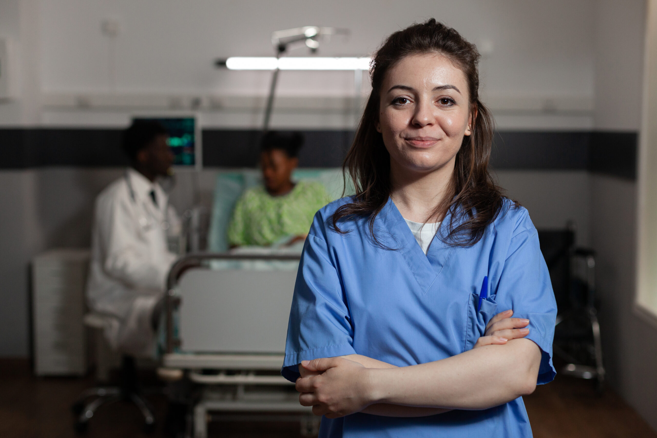 Portrait of specialist physician assistant standing in hospital ward during medical consultation